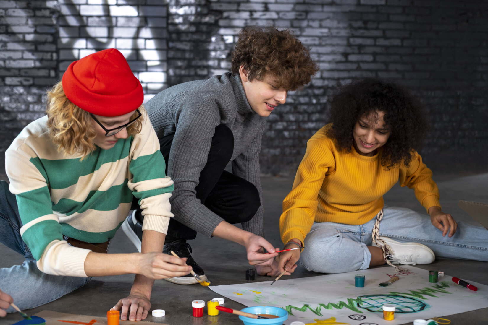 A group of young people painting a banner together
